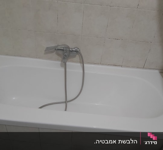 אמבטיה לבנה עם ברז וכיסוי קיר קרמי